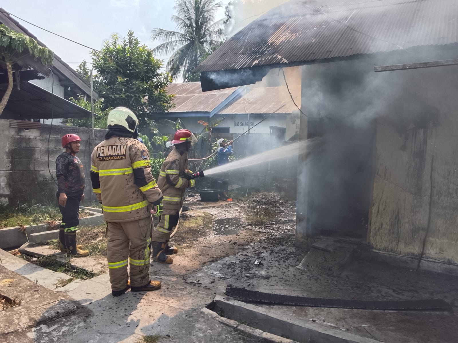 Petugas melakukan pemadaman di barak dua pintu di Panarung yang terbaka